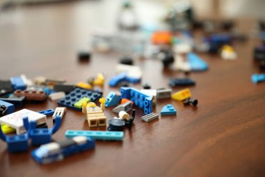 Ahşap masada renkli plastik oyuncak arabalar.