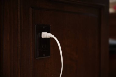 Karanlık odada beyaz elektrik prizi.