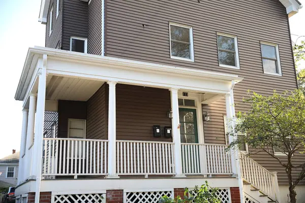 Eski ahşap bir evin dikey görüntüsü ve tuğladan bir merdiven.