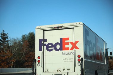 Yeni bir yolun önüne büyük bir kırmızı teslimat kamyonu park etti..