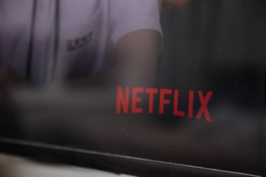 Netflix logosu ve ekranda netflix logosu. Netflix, Amerikan yayıncılık ve Netflix 'in oynadığı bir video oyunudur. Amerikan Netflix 'i tutuluyor.