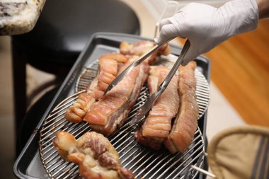 Izgarada lezzetli sosisler hazırlayan kadın, yakın plan.