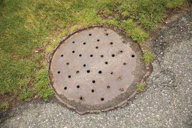 Sokaktaki eski paslı çukur.