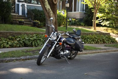 Bir şehirde park etmiş bir motosikletin dikey görüntüsü.