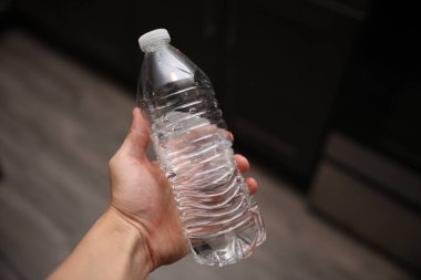 Kadın elinde plastik bardak su tutuyor..