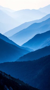 Dağları ve mavi gökyüzü olan güzel bir manzara.