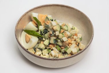 İçinde doğranmış salatalık, dilimlenmiş haşlanmış yumurta, doğranmış yeşil soğan ve% 20 'lik ekşi krema sosunun seramik kasede yer aldığı taşra salatasının en iyi görüntüsü. Sağlıklı beslenme, yemek blogları ve yemek fotoğrafçılığı için mükemmel.. 