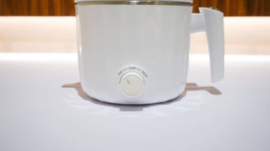 Beyaz elektrikli buhar makinesi, yemek pişirmek için kullanılan bir mutfak gereçleridir. Aynı anda buhar kullanarak yiyeceğin yerleştirilip pişirilebileceği birden fazla katmanı ya da bölmesi var..