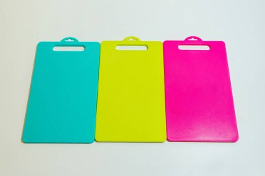 Mavi, Sarı ve Pembe Plastik Kesme Tahtası bir dizi canlı ve pratik mutfak gereksinimleridir..
