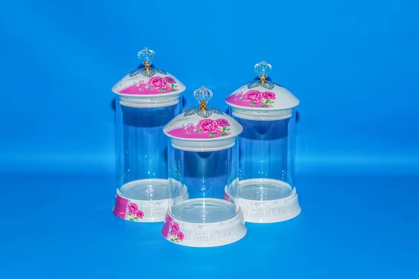 带有陶瓷盖子和粉红花盆的玻璃瓶是一个漂亮实用的厨房或家庭存储解决方案 — 图库照片