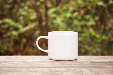 Tahta masada yeşil çay olan beyaz fincan.