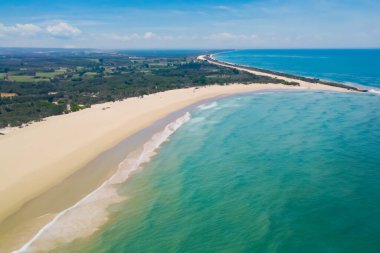 aerial view of the beach with sand and waves