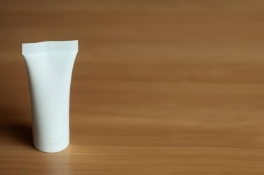 Kahverengi bir arkaplanda fotokopi alanı olan boş beyaz plastik şişe