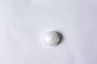 Beyaz kağıtlı arka planda hap olan yuvarlak bir hap.