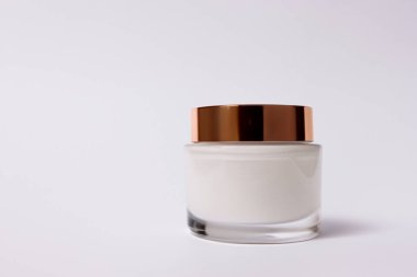 Bej arka planda bir şişe kozmetik kremi.