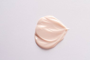 yüz kremi ve nemlendirici pembe kağıt üzerinde