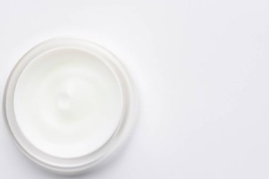 Beyaz arka planda beyaz yuvarlak kozmetik krem kavanozu, üst görünümde, düz yerde, kopyala - boşluk