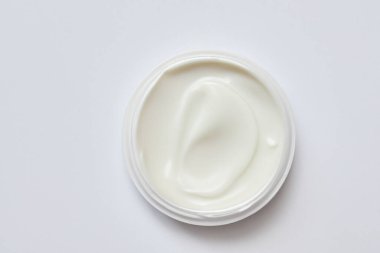 Cam kavanozda beyaz krema ve hafif arka plan.