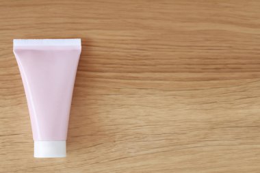 Ahşap arka planda krem için kozmetik tüp