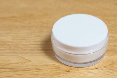 Ahşap arka planda beyaz kozmetik konteynır