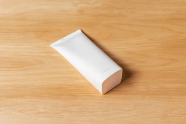 Ahşap arka planda beyaz şampuan şişesi.