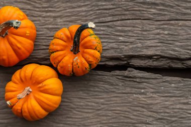 Cadılar Bayramı kompozisyonu. Eski ahşap masada turuncu ve siyah balkabakları. düz alan, üst görünüm, kopyala boşluk.