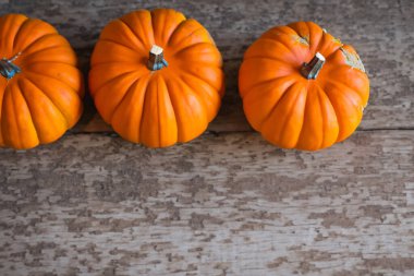 Cadılar Bayramı kompozisyonu Ahşap masanın üzerinde balkabakları.