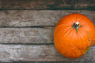 Ahşap zemin üzerinde turuncu ve beyaz balkabağı.