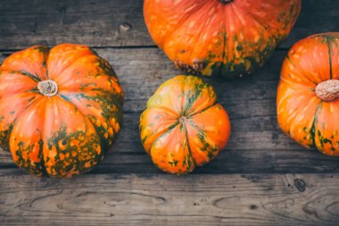 Ahşap masa arkasında Cadılar Bayramı balkabağı.