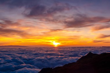 Dağlardaki bulutların üzerinde gün doğumu