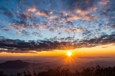 Bulut ve güneşle dağda gün doğumu
