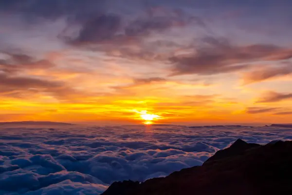 山の雲の上に日が昇る — ストック写真