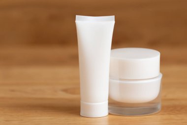 Kozmetik krem şişesi, markalaşma için boş etiket, ahşap arka planda..