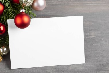 İçinde boş kağıt ve ahşap zeminde noel ağacı dalı olan Noel kartı.
