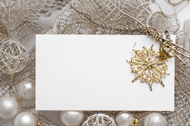 Altın Noel tebrik kartı ve beyaz arka planda noel süslemeleri, düz yatış