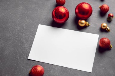 Kırmızı incik boncuklu Noel tebrik kartı ve beyaz arka planda noel süslemeleri. Noel tebrik kartı maketi. Üst Manzara. düz yat