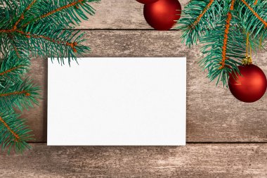 Noel ağacıyla beyaz kağıt ve ahşap masa zemininde noel süslemeleri.