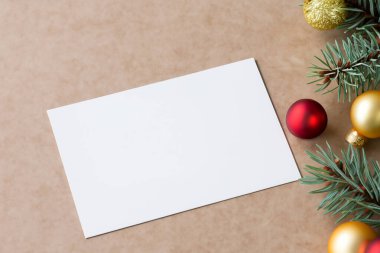 Noel süsleri, çam dalları ve düz yataklı boş Noel tebrik kartı. en üstteki görünüm