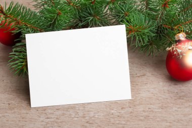 Noel kartı, beyaz ahşap masa arkaplanında noel süslemeleri ile birlikte.