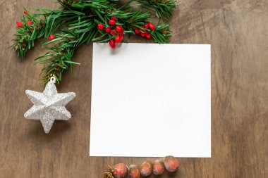 Boş kağıt ve noel süslemeleri ahşap masada, düz yerde. Metin için boşluk