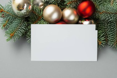Noel kompozisyonu. Boş kart, köknar ağacı dalları ve gri arka planda süslemeler. Üst manzara, düz yatış. kopyalama alanı. Noel tebrik kartı şablonu