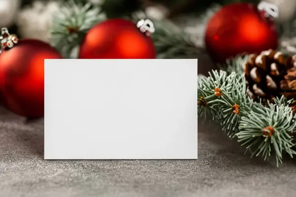 Noel arkaplanı köknar dalları, dekorasyonlar ve boş kartlarla dolu.