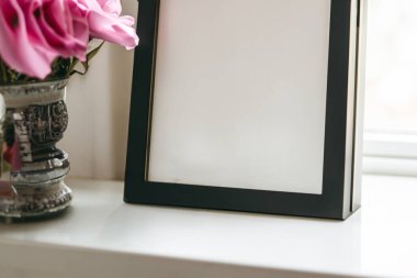 Odada çiçekli boş fotoğraf çerçevesi