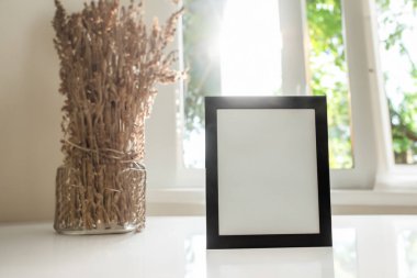 Yatak odasındaki ahşap zeminde beyaz çerçeveli boş resim çerçeveleri.