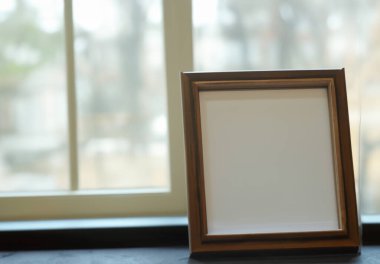 Ahşap bir arkaplanda boş beyaz çerçeve