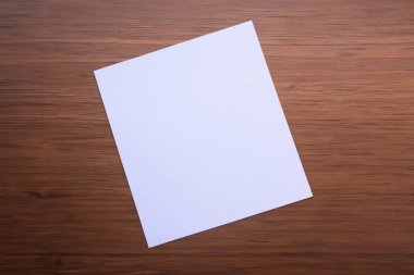 Tahta bir yüzey üzerinde boş beyaz kağıt levha