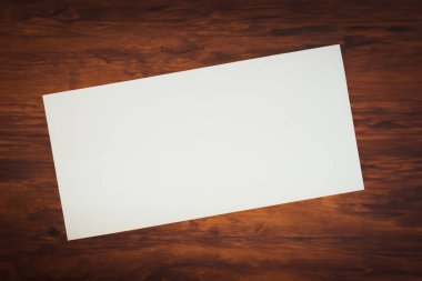 Ahşap arka plan üzerinde beyaz kart.