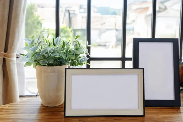 blank frames on wooden table in modern home interior
