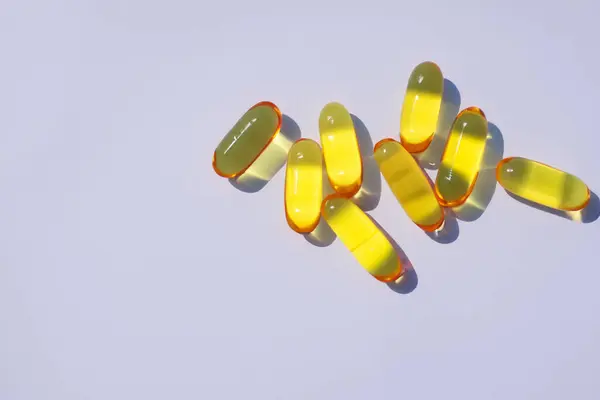 yellow pills and capsules on a white background.