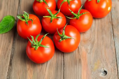 Tahta bir masada taze kırmızı domatesler.